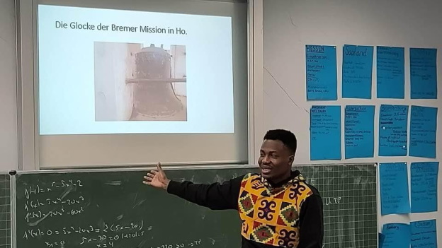 Samuel, Student aus Ghana stellt die Glocke der Bremer Mission in Ho, Ghana, vor.