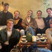 Sieben Mitglieder des Standortteams Heidelberg sitzen in einem Café.