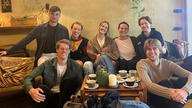 Sieben Mitglieder des Standortteams Heidelberg sitzen in einem Café.